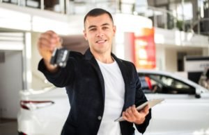 Driver profesional memegang kunci mobil sebelum melayani pelanggan rental mobil dengan sopir di Jakarta