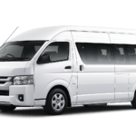 Toyota Hiace Commuter putih tampak serong depan dan samping untuk layanan sewa Hiace Jakarta dengan driver profesional